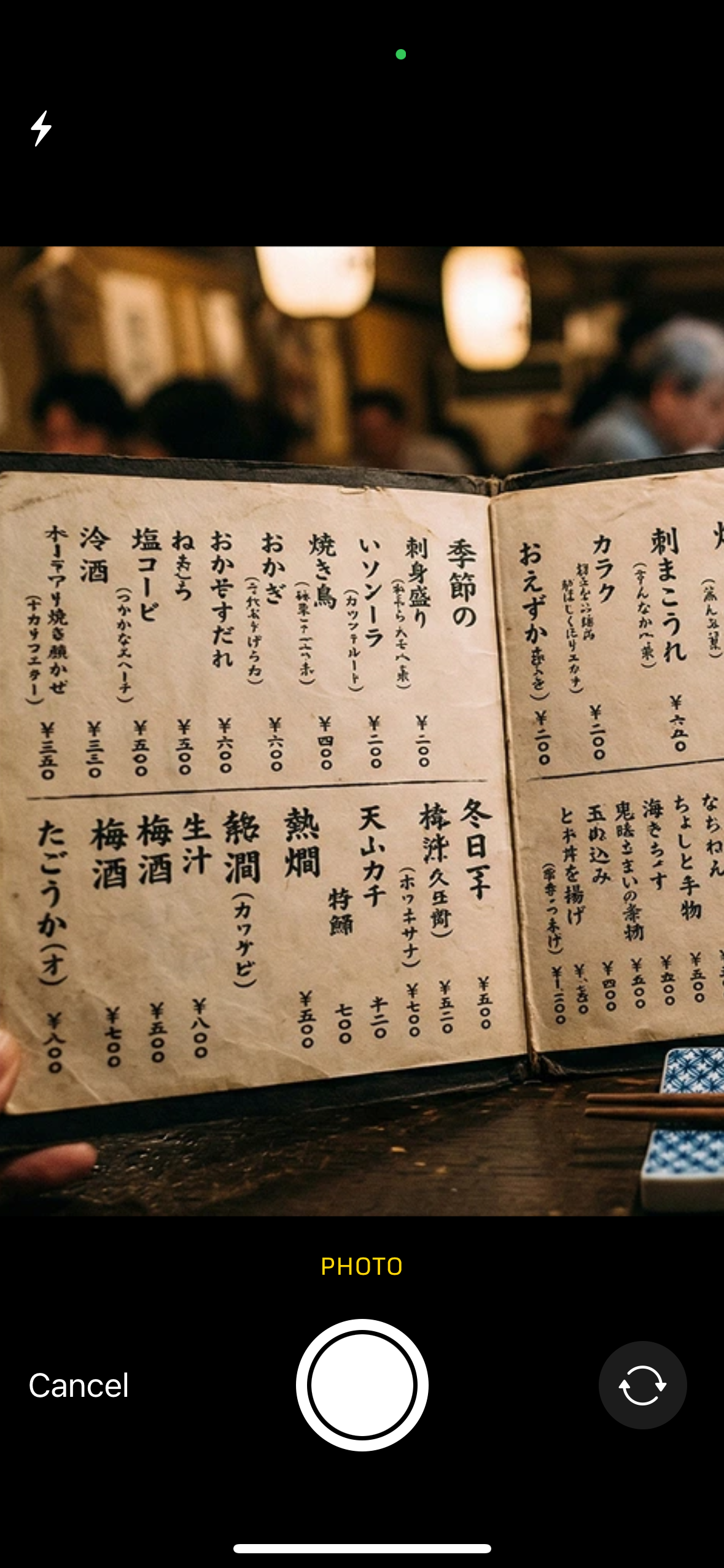 Taking a photo of a handwritten Japanese menu inside a restaurant